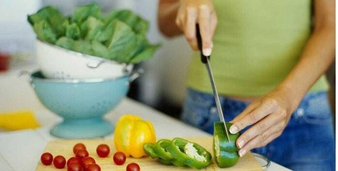 Cucina un'insalata di verdure per cena seguendo i principi di una corretta alimentazione per una figura snella